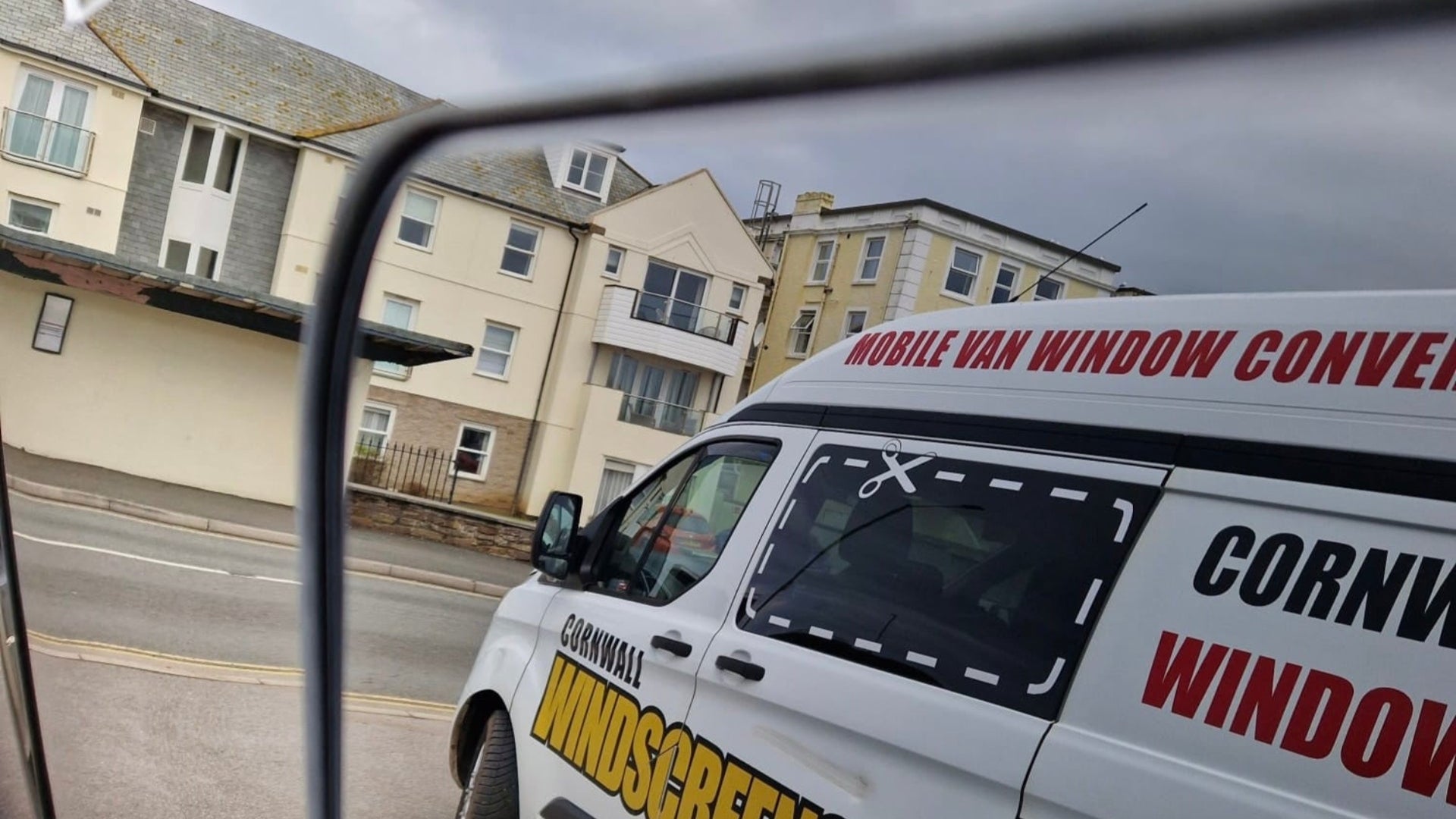 Van with 'Cornwall Window Screens' branding on a street.